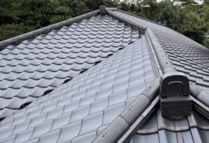 瓦からの水滴が長年落ちた結果、柔らかい銅板の谷樋に起こった事